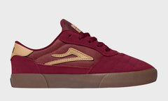 Maroon sneaker with gold accents on a white background