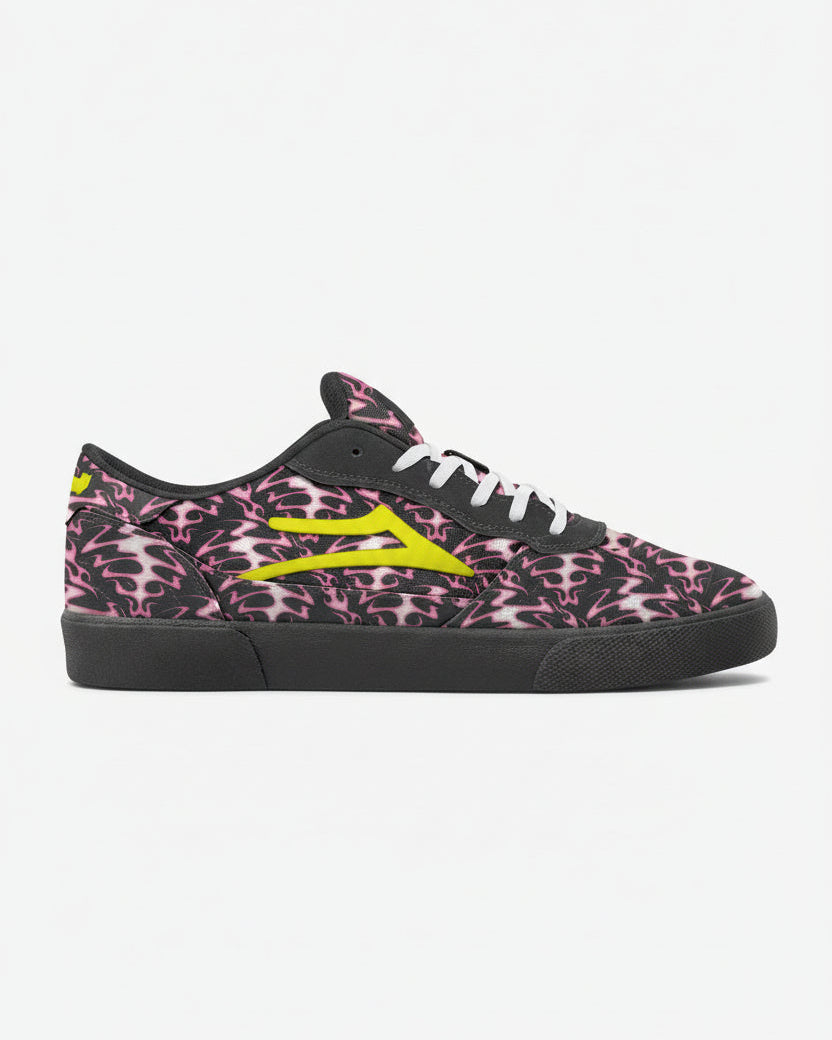 Black sneaker with pink skull pattern and yellow accents on a white background